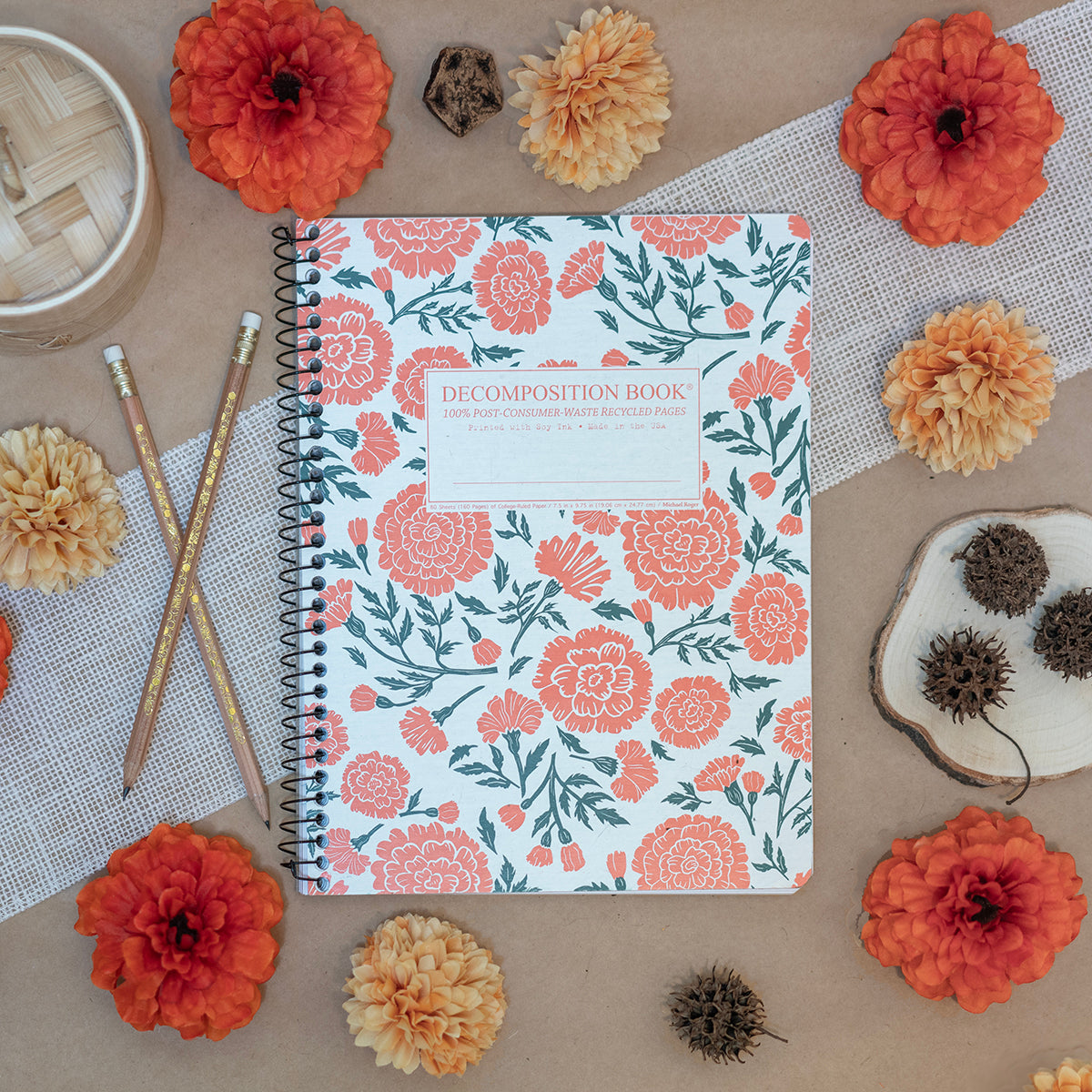 Spiral notebook printed with a pattern of large flowers in orange and green