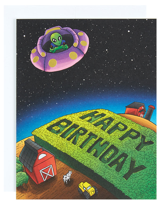 Greeting card with the text Happy Birthday written in crops by an alien