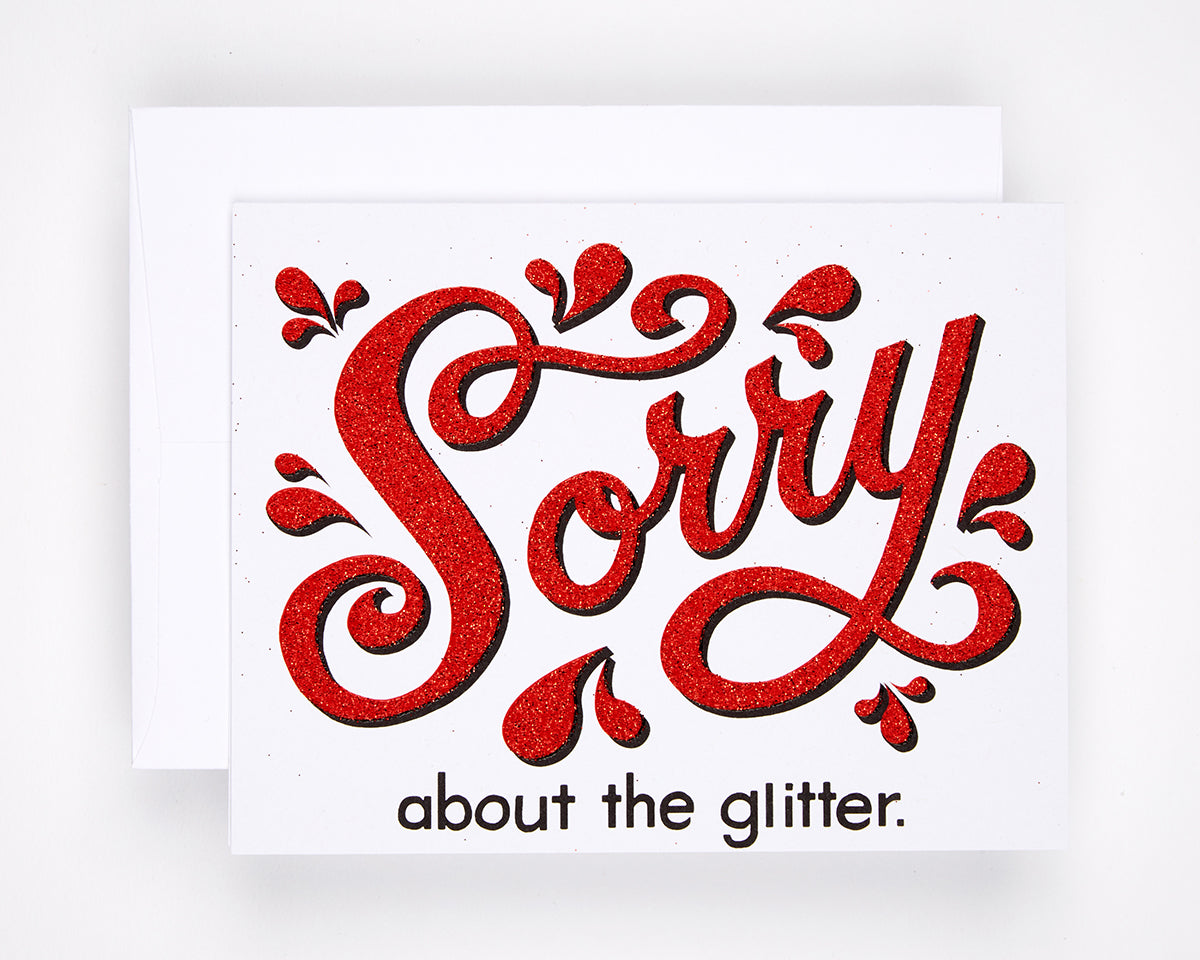Greeting card printed with Sorry about the glitter in red glitter text
